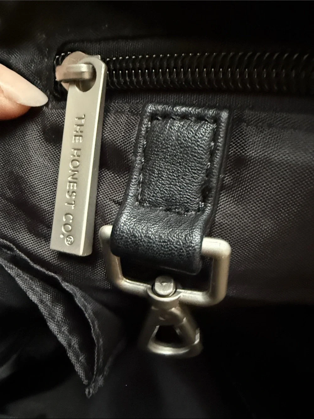 The Honest Company Black Vegan Leather Diaper Bag backpack model cross country
